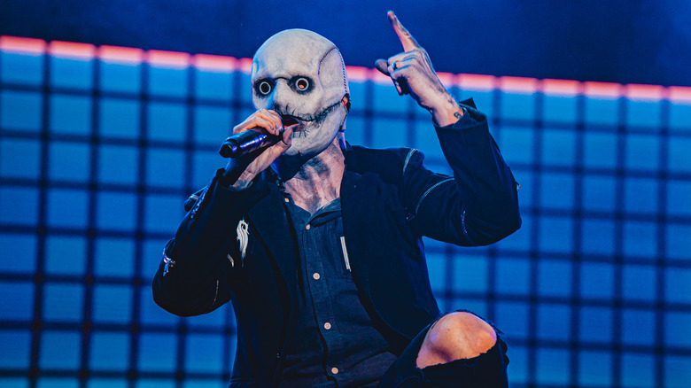 Slipknot's Corey Taylor holding his finger up in the air during a concert