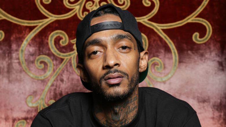 Nipsey Hussle looking serious and staring into camera